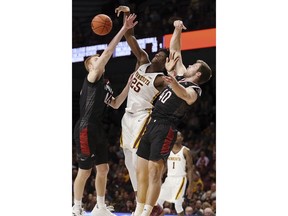 Minnesota's Daniel Oturu (25) rebounds against Nebraska-Omaha's Mitchell Hahn (44) and Matt Pile (40) during an NCAA college basketball game Tuesday, Nov. 6, 2018, in Minneapolis.