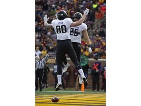Northwestern running back Isaiah Bowser (25) celebrates with teammate wide receiver Trey Pugh after Bowser scored a touchdown against Minnesota during an NCAA college football game Saturday, Nov. 17, 2018, in Minneapolis.