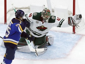 Minnesota Wild goaltender Devan Dubnyk, right, gloves the puck as St. Louis Blues' Robby Fabbri (15) watches during the first period of an NHL hockey game Sunday, Nov. 11, 2018, in St. Louis.