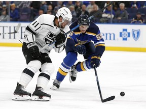 Los Angeles Kings' Anze Kopitar (11), of Slovenia, and St. Louis Blues' Colton Parayko chase after a loose puck during the first period of an NHL hockey game Monday, Nov. 19, 2018, in St. Louis.