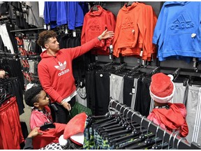 Kansas City Chiefs quarterback Patrick Mahomes shops with youth football players from KC United at the Dick's Sporting Goods store in Leawood, Kansas, Tuesday, Nov. 27, 2018. Mahomes had taken time out of his day off to surprise the kids. He took photographs, signed autographs and presented the team's founder, local pastor Adrian Roberson, with $5,000 to fund next season. "I have no words for it," said Roberson, who broke into tears.