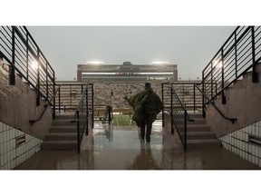 A lone fan runs into Memorial Stadium during a rain shower before the start of the Arkansas-Missouri NCAA college football game Friday, Nov. 23, 2018, in Columbia, Mo.