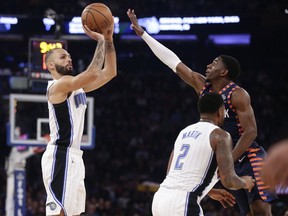 Orlando Magic's Evan Fournier, left, shoots over New York Knicks' Damyean Dotson during the first half of an NBA basketball game Sunday, Nov. 11, 2018, in New York.