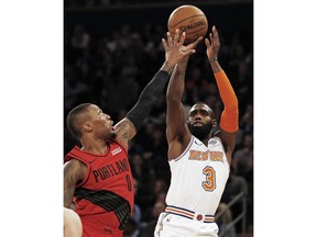 New York Knicks guard Tim Hardaway Jr. (3) shoots over Portland Trail Blazers guard Damian Lillard (0) during the first half of an NBA basketball game Tuesday, Nov. 20, 2018, in New York.