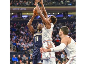 New Orleans Pelicans guard Jrue Holiday (11) works against New York Knicks guard Frank Ntilikina (11) in the first quarter of an NBA basketball game, Friday, Nov. 23, 2018, in New York.