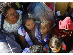 Migrants traveling with a caravan hoping to reach the U.S. border, wait to board a bus in La Concha, Mexico, Wednesday, Nov. 14, 2018. Buses and trucks are carrying some migrants into the state of Sinaloa along the Gulf of California and further northward into the border state of Sonora. The bulk of the main caravan appeared to be about 1,100 miles from the border, but was moving hundreds of miles per day.