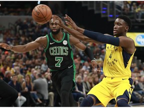 Indiana Pacers guard Victor Oladipo, right, passes the basketball defended by Boston Celtics guard Jaylen Brown during an NBA basketball game, Saturday, Nov. 3, 2018, in Indianapolis.