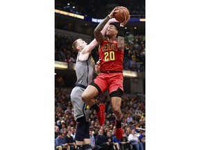 Indiana Pacers forward Domantas Sabonis, left, fouls Atlanta Hawks forward John Collins (20) as he attempts to shoot during the first half of an NBA basketball game, Saturday, Nov. 17, 2018, in Indianapolis.