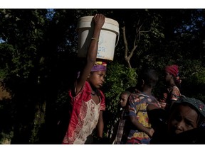In this photo taken Friday, Sept. 7, 2018, internally displaced people gather water from a natural spring at Elevage camp in Bambari, Central African Republic. Children are bearing the brunt of five years of fighting in Central African Republic, according to a new report by the United Nations children's agency released Friday, Nov. 30, 2018.