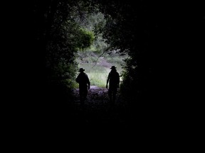 In this Oct. 18, 2018 photo, park rangers Agustin Mezzabotta, right, and Gonzalo Alves walk at "Ciervo de los Pantanos" National Park near Buenos Aires, Argentina. The until-now little-known area, home to a wide range of birds, fish and other wildlife, has become Argentina's newest national park in a victory for nature preservation at a time when the country is facing an economic crisis and governments worldwide are cutting back funding for parks and environmental programs.