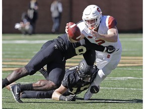 Syracuse's Eric Dungey (2) reaches for a first down as Wake Forest's Luke Masterson (12) and Chris Calhoun (6) defend in the first half of an NCAA college football game in Charlotte, N.C., Saturday, Nov. 3, 2018.