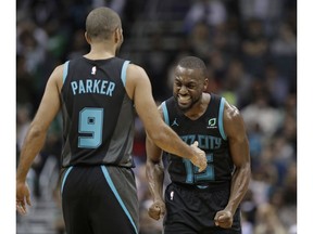 Charlotte Hornets' Kemba Walker (15) celebrates with Tony Parker (9) after Parker's basket against the Boston Celtics late in the second half of an NBA basketball game in Charlotte, N.C., Monday, Nov. 19, 2018.