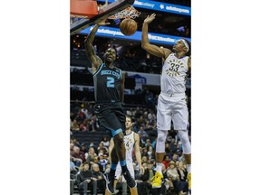 Charlotte Hornets forward Marvin Williams, left, dunks next to Indiana Pacers center Myles Turner during the first half of an NBA basketball game in Charlotte, N.C., Wednesday, Nov. 21, 2018.