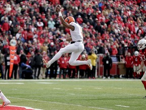 Illinois quarterback AJ Bush Jr. (1) leaps into the end zone for a touchdown ahead of Nebraska defensive back JoJo Domann (13), during the first half of an NCAA college football game in Lincoln, Neb., Saturday, Nov. 10, 2018.