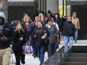 People leave the the First National Bank tower after the building was evacuated  after cleaning solution fumes spread through the building and sent several people to the hospital Thursday Nov 8, 2018 in Omaha, Nebraska.