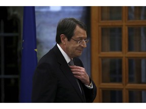 Cyprus' president Nicos Anastasiades adjusts his tie before giving a statement to the media at the presidential palace in divided capital Nicosia, Cyprus, Tuesday, Nov. 6, 2018. Anastasiades holds news conference to elaborate on his vision on how the ethnically split island nation could be reunified as a decentralized federation.