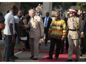 Prince Charles, left, greets war veterans as Ghana's President, Nana Akufo-Addo, right, looks on in Accra, Ghana, Friday, Nov. 2, 2018. Prince Charles and his wife Camilla, the Duchess of Cornwall, have arrived in Ghana for the second stop of their West African tour.