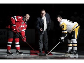 Former New Jersey Devils goalkeeper Martin Brodeur, center, poses for photographs with Devils defenseman Andy Greene, left, and Pittsburgh Penguins center Sidney Crosby during the ceremonial puck drop prior to an NHL hockey game, Tuesday, Nov. 13, 2018, in Newark, N.J.