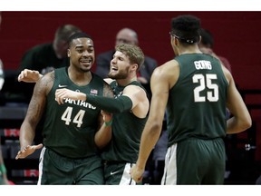 Michigan State forward Nick Ward (44) is hugged by Kyle Ahrens after scoring a basket against Rutgers during the first half of an NCAA college basketball game, Friday, Nov. 30, 2018, in Piscataway, N.J.