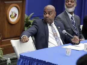 A water bottle belonging to Newark Mayor Ras Baraka, left, rests behind him as he and Kareem Adeem, the city's deputy director of water and sewer utilities, take questions from a reporter during a news conference talking about levels of lead in the city's tap water, Thursday, Nov. 8, 2018, in Newark, N.J. Baraka said Thursday his administration is taking multiple steps to address the high levels caused by aging lead water lines. Meanwhile, a lawsuit claims the city hasn't taken adequate precautions and has misled residents. Between 15,000 and 18,000 homes are estimated to have the lead lines.