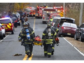 Firefighters carry a stretcher to the scene of a fatal fire at 15 Willow Brook Rd. Tuesday, Nov. 20, 2018, in Colts Neck,N.J. Authorities say two adults and two children were found dead at the scene of a burning mansion near the New Jersey shore. Monmouth County prosecutor Christopher Gramiccioni says the fire continues to burn late Tuesday afternoon at the two-story home in Colts Neck. He says one body was found out front. He is not yet identifying the victims.