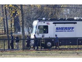 Law enforcement officials gather Wednesday, Nov. 21, 2018, in Colts Neck,N.J., to investigate the aftermath of fatal fire that killed two children and two adults. Authorities say two adults and two children were found dead the day before at the scene of a burning mansion near the New Jersey shore.