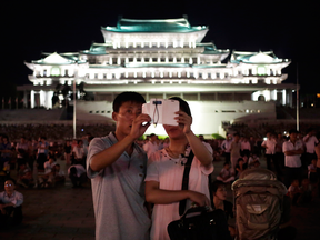 A North Korean couple use their locally made smartphone to photograph fireworks. The regime is banking on an easing of U.S. sanctions to spur modernization plans.