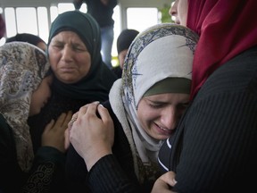 Mourners cry during the funeral of Palestinian Mohammed Shreteh in the West Bank village of Mazraa al-Gharbiya, near Ramallah, Sunday, Nov. 11, 2018. Shreteh succumbed to his wounds that were sustained during clashes with Israeli soldiers in the village last month.