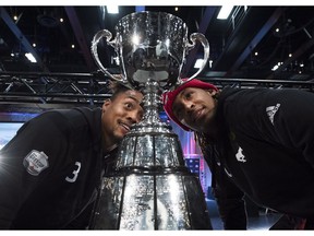 Calgary Stampeders defensive back Patrick Levels, left, and Stampeders wide receiver Bakari Grant, right, eye up the Grey Cup during media day ahead of the106th Grey Cup in Edmonton on Thursday, November 22, 2018.
