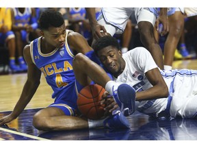 UCLA's Jaylen Hands, left, battles for a loose ball against North Carolina's Brandon Robinson during the second half of an NCAA college basketball game Friday, Nov. 23, 2018, in Las Vegas.