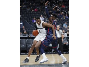 Utah State's Dwayne Brown Jr. drives around Saint Mary's Malik Fitts during the first half of a NCAA college basketball game Monday, Nov. 19, 2018, in Las Vegas.