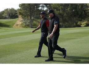 Phil Mickelson, right, and Tiger Woods laugh as they walk up the second fairway during a golf match at Shadow Creek golf course, Friday, Nov. 23, 2018, in Las Vegas.