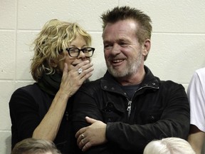 FILE - In this Dec. 31, 2011 file photo, Actress Meg Ryan, left, talks with performer John Mellencamp during the second half of an NCAA college basketball game between Indiana and Ohio State in Bloomington, Ind.  Mellencamp and Ryan are getting married. Ryan announced her engagement on Instagram. "ENGAGED!," is what she wrote. The post included a drawing of what appears to be the two holding hands. He's also holding a guitar.