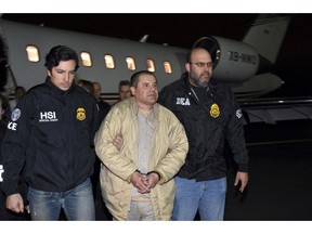 FILE - In this Jan. 19, 2017 file photo provided by U.S. law enforcement, authorities escort Joaquin "El Chapo" Guzman, center, from a plane to a waiting caravan of SUVs at Long Island MacArthur Airport, in Ronkonkoma, N.Y. Guzman's trial is set to begin Monday, Nov. 5, 2018, with jury selection. Opening statements are expected on Nov. 13. (U.S. law enforcement via AP, File)