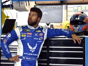 FILE - In this July 28, 2018, file photo, Bubba Wallace stands in the garage area during practice for a NASCAR Cup Series auto race in Long Pond, Pa. Wallace has two races remaining in a rookie season with a storybook beginning at the Daytona 500. He finished second, the highest ever for a minority in NASCAR's version of the Super Bowl, and it launched Wallace into the national spotlight.