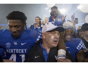 FILE - In this Sept. 22, 2018, file photo, Kentucky coach Mark Stoops celebrates with players and fans on the field after the team's 28-7 win over Mississippi State in an NCAA college football game, in Lexington, Ky. While at least one coach has been fired already in each of the other Power Five conferences, the SEC doesn't have anyone on an obvious hot seat heading into the final weekend of the regular season. Barring a surprise move, 2019 would mark the first time since 2006 that the SEC begins a season with no new head coaches.