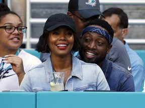 FILE - In this Sunday, Oct. 14, 2018 file photo, Miami Heat player Dwyane Wade and his wife Gabrielle Union-Wade acknowledge the cheers from the crowd during the second half of an NFL football game between the Miami Dolphins and the Chicago Bears in Miami Gardens, Fla. Miami Heat star Dwyane Wade and his wife Gabrielle Union-Wade have a baby. The couple on Thursday, Nov. 8, 2018 announced they've welcomed a baby girl into the world.