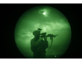 In this Monday, April 21, 2008 file photo, a U.S soldier looks through the scope of his weapon during a night patrol in Mandozai, in Khost province, Afghanistan, seen through night vision equipment. About 400,000 veterans had a PTSD diagnosis in 2013, according to the Veterans Affairs health system.