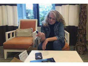 In this Nov. 1, 2018 photo, Polly Varnado looks at her daughter's Medtronic insulin pump in Destin, Fla. Medical device manufacturers and experts say insulin pumps are safe. But an AP investigation found that insulin pumps and their components are responsible for the highest number of malfunction, injury and death reports in the U.S. Food and Drug Administration's medical device database.