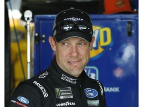 FILE - In this May 11, 2018, file photo, driver Matt Kenseth stands in the garage area before a practice run for a NASCAR Cup Series auto race at Kansas Speedway in Kansas City, Kan. NASCAR's driver carousel will spin long after the season finale. Former Cup champions Kenseth and Kurt Busch, and Daniel Suarez, AJ Allmendinger, Regan Smith and Jamie McMurray are among the drivers certain to start next season with new teams or new roles.