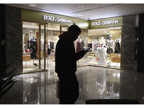 FILE - In this Nov. 21, 2018, file photo, a man walks past a Dolce&Gabbana store in Beijing, China. Dolce&Gabbana faced a boycott after Chinese netizens expressed outrage over what were seen as culturally insensitive videos promoting a major runway show in Shanghai and subsequent posts of insulting comments in a private Instagram chat.