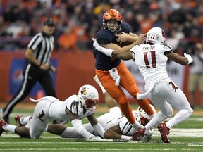Syracuse quarterback Eric Dungey, left, eludes Louisville safety Dee Smith (11) during the first half of an NCAA college football game in Syracuse, N.Y., Friday, Nov. 9, 2018.