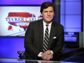 FILE - In this March 2, 2017, file photo, Tucker Carlson, host of "Tucker Carlson Tonight," poses for photos in a Fox News Channel studio in New York. Washington police are investigating a protest outside the home of Carlson as a possible hate crime. According to a police report, a group of demonstrators gathered outside Carlson's Northwest Washington home Wednesday night, Nov. 7, 2018. A video posted on social media but later removed shows people standing outside a darkened home chanting "Tucker Carlson we will fight/We know where you sleep at night."
