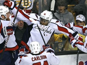 FILE - In this April 25, 2012, file photo Washington Capitals right wing Joel Ward, center, is congratulated by teammates after scoring the game-winning goal against the Boston Bruins during overtime in Game 7 of an NHL hockey Stanley Cup first-round playoff series in Boston. In 2014, then-Capitals forward Joel Ward was also the subject of racial social media posts after he scored a game-winning playoff goal.