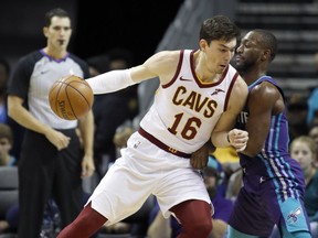 FILE - In this Saturday, Nov. 3, 2018, file photo,  Cleveland Cavaliers' Cedi Osman (16) leans a shoulder into Charlotte Hornets' Kemba Walker (15) during the first half of an NBA basketball game in Charlotte, N.C. The Cavaliers' list of injured players continues to grow. Starting forward Cedi Osman will miss at least one game with back spasms, the fourth Cleveland player sidelined by an injury.