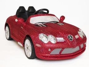 This image released by FAO Schwarz shows a ride-on Mercedes-Benz adorned with more than 44,000 Swarovski crystals in glittery red, white and black for $25,000. (FAO Schwarz via AP)