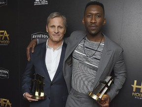 FILE - In this Nov. 4, 2018 file photo, Viggo Mortensen, left, and Mahershala Ali, winners of the ensemble award for "Green Book," pose in the press room at the Hollywood Film Awards in Beverly Hills, Calif. Mortensen has apologized for using a racial slur during a panel discussion about his new film. Mortensen told The Hollywood Reporter on Thursday he was making the point that many people casually used the slur in 1962. In "Green Book," Mortensen's character is hired to drive an African-American pianist on a concert tour in the South.