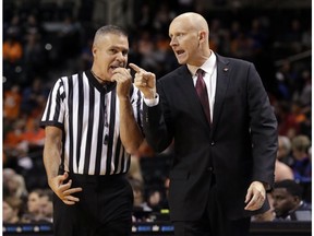 Louisville head coach Chris Mack argues a call with a referee during the first half of an NCAA college basketball game against Tennessee in the NIT Season Tip-Off tournament Wednesday, Nov. 21, 2018, in New York.