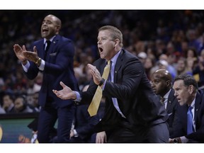 Marquette coach Steve Wojciechowski cheers for his team during the first half of an NCAA college basketball game against Kansas in the NIT Season Tip-Off tournament Wednesday, Nov. 21, 2018, in New York.