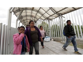 FILE- In this Saturday, Nov. 3, 2018, file photo immigrants seeking asylum in the United States walk off of the the International Bridge in Reynosa, Mexico. Asylum seekers already camping at border crossings worry that how the Trump administration responds to the caravan of some 4,000 Central American migrants and three much smaller ones hundreds of miles behind it could leave them shut out.